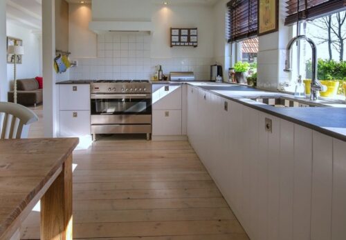 Nach einer gelungenen Küchensanierung erstrahlt diese Küche in klarem Weiß, harmonisch ergänzt durch den warmen Holzfußboden. Dank der beiden Fenster wird der Raum lichtdurchflutet und unterstreicht das frische, moderne Design.