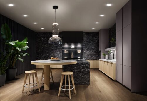 Die Küche aus der Serie „Mondial“ von SieMatic erscheint wie ein Gesamtkunstwerk. Die Insel ist ansprechend gestaltet mit Marmor und Glaselementen. Schön ist das gerundete Ende mit Sitzplatz.