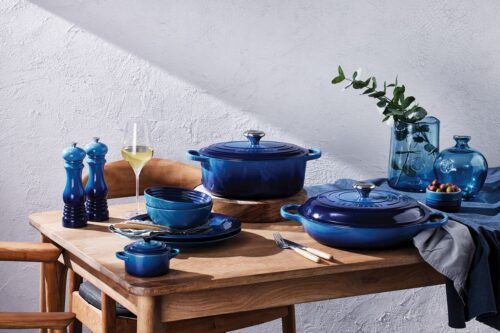 Ein Gusseisenbräter von Le Creuset in der Farbe Azure präsentiert sich nicht nur als funktionaler Küchenhelfer, sondern auch als stilvolles Dekorationsobjekt auf dem Esstisch.