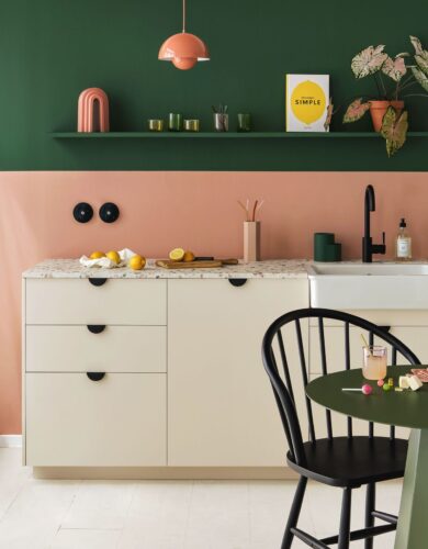 Ein gelungener Kontrast ist die Kombi aus Grün und dem Apricot-Ton. Damit es stimmig aussieht, sollten beide Farben nochmal in der Küche auftauchen. Das kann bei Möbelstücken sein, aber auch bei Accessoires. Die Küche ist von Plum Living.