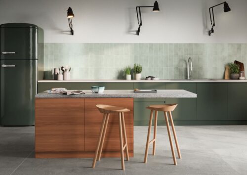 Die Farbe Salbeigrün ist ein Farbtupfer für die Küche. Dadurch bekommt der Raum eine mediterrane Note. Stilvoll sehen dazu die natürlich changierenden Fliesen von Agrob-Buchtal aus. Interessant ist die Anordnung, die hochkant und nicht quer ist.
